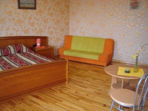 a bedroom with a bed and a chair and a table at Ventspils Apartments in Ventspils