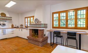 una cucina con camino e due sgabelli da bar di Villa El Torreón a Casarabonela