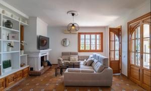 un soggiorno con divano e camino di Villa El Torreón a Casarabonela