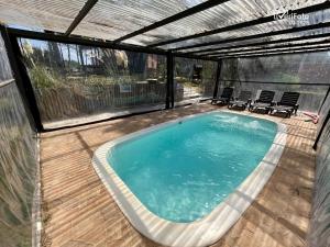 a large swimming pool with chairs in a backyard at Chimuelo, es necesario hacer sena para reservar in Punta Del Diablo