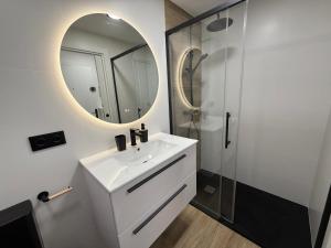 un bagno bianco con lavandino e specchio di Estudio Playa Calpe a Calpe