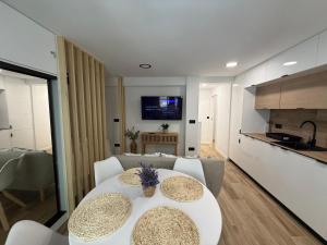 un soggiorno con un tavolo bianco e una cucina di Estudio Playa Calpe a Calpe Altre 5 foto