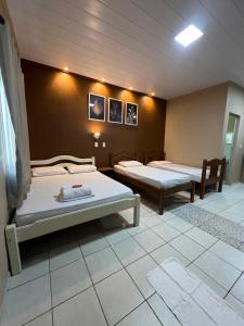 a room with two beds in a room at Chalé em Parque Aquático - Presidente Figueiredo in Presidente Figueiredo
