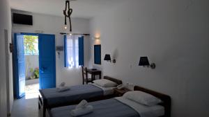sypialnia z 2 łóżkami, oknem i drzwiami w obiekcie Laokasti Villas w mieście Oia