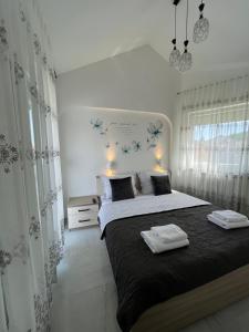 a bedroom with a large bed with two towels on it at Apartments Ostojic in Krk