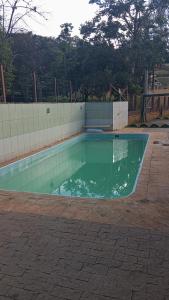 a swimming pool with green water in a yard at CHÁCARA recanto das nuvens 2 in Arujá