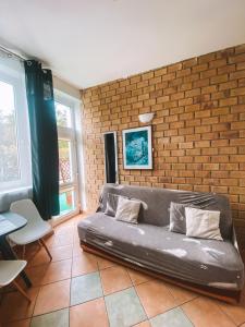 a couch in a room with a brick wall at Dom na Fali Darlowko in Darlowko