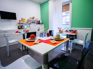 a kitchen with a table and two tables and chairs at Amuri Room&Suite in Palermo
