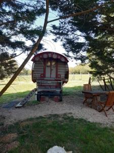 mały plac zabaw ze zjeżdżalnią i ławką w obiekcie Roulotte irlandaise Polly w mieście Saint-Vincent-en-Bresse
