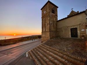 een oud gebouw met een klokkentoren aan de kant van een straat bij B&B La Palma in Petacciato