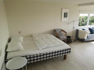 a bedroom with a bed and a table and a chair at Beach Cottages in Höllviken