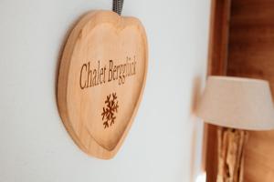 a wooden heart hanging on a wall next to a lamp at Chalet Bergglück in Piesendorf +32 photos