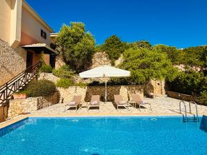 a pool with chairs and an umbrella next to a house at The Lookout, boutique villa. in Sivota
