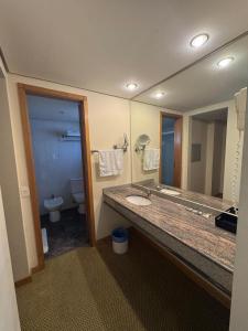 a bathroom with a sink and a toilet and a mirror at Hotel & Residência Alphaville in Barueri +19 photos