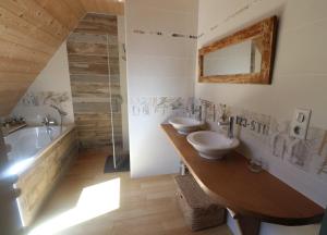 a bathroom with two sinks and a bath tub at La Fermette de Loucheyre in Saint-Amandin