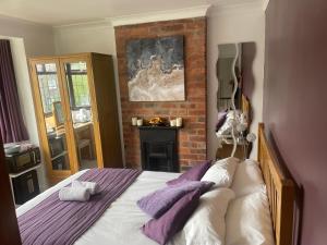 a bedroom with a bed and a brick wall at Camaraderie Guest House in York
