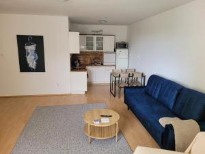a living room with a blue couch and a kitchen at Neva Trnava 2 in Trnava