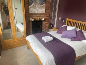 a bedroom with a bed with purple and white pillows at Camaraderie Guest House in York