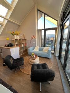 Una sala de estar con un sofá y sillas y una mesa. en Appartement Oan it Pikmar, en Grou