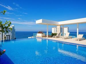 a swimming pool with a view of the ocean at Neos Apartments – Near the Sea by SOHO in Santa Marta +34 photos