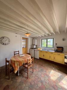 a large kitchen with a table in a room at Maison de Tout Vent in Pierrefonds