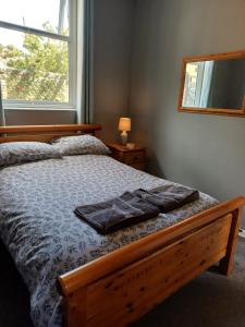 a bedroom with a wooden bed with a mirror on it at Home from Home in Faversham