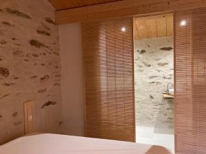 Un dormitorio con una cama y una pared de piedra. en Gîte Le COCON au Clarou, en Valleraugue 13 fotos más