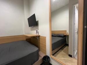 a small room with two beds and a mirror at ONE rooms ungaran in Ungaran +11 photos