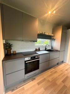 a kitchen with stainless steel appliances and a window at Casa Båstad in Båstad +12 photos