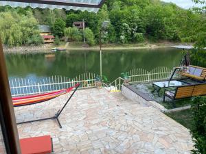 Una vista de un lago con una hamaca y una mesa. en Leo Green House, en Moara Ungurului