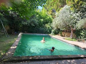 two people swimming in a swimming pool at Au coeur d'Uzès in Uzès