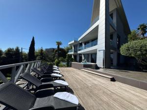 a row of chaise lounges on a deck near a building at Apartment Villa Marjanovic in Opatija