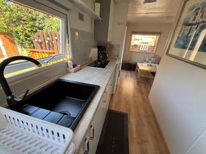 a kitchen with a sink and a counter top at Domek holenderski Lilla in Łeba