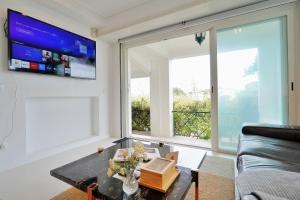 a living room with a table and a large window at Mbird Estoril Riviera Flat 3 in Estoril