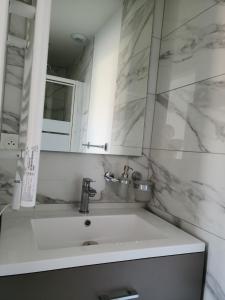 un bagno bianco con lavandino e specchio di STRASBOURG CENTRE HISTORIQUE Accès direct en Tram et Aéroport a Lingolsheim Altre 9 foto