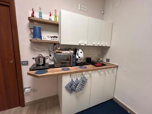 a kitchen with white cabinets and a counter top at Armonica Apartment in Castellammare di Stabia