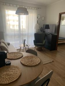 salon ze stołem i krzesłami oraz salon w obiekcie Apartament NANO z klimatyzacją w mieście Giżycko
