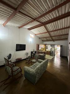a living room with a couch and chairs and a flat screen tv at Las Reinas House Rental in Inírida