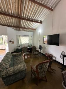a living room with a couch and chairs and a television at Las Reinas House Rental in Inírida +4 photos