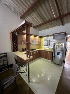 a kitchen with wooden cabinets and a stainless steel refrigerator at Las Reinas House Rental in Inírida