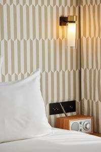 a bedroom with a bed and a night stand with a radio at Hôtel Noucha in Paris