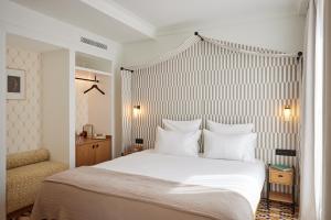 a bedroom with a large bed with white sheets and pillows at Hôtel Noucha in Paris