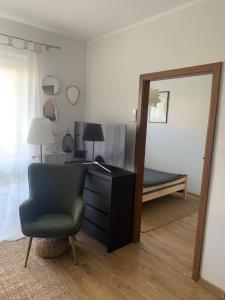 sypialnia z biurkiem, krzesłem i lustrem w obiekcie Apartament NANO z klimatyzacją w mieście Giżycko