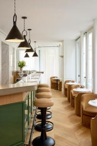 a row of stools at a bar in a restaurant at Hôtel Noucha in Paris