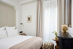 a bedroom with a white bed and a window at Hôtel Noucha in Paris