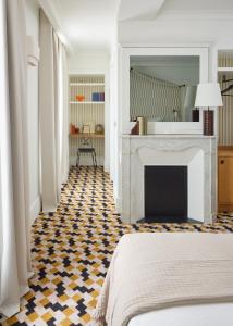 a bedroom with a fireplace and a bed and a floor at Hôtel Noucha in Paris