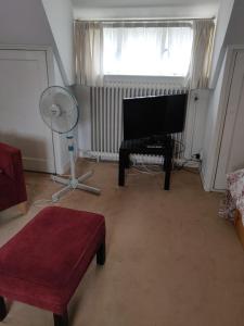 a living room with a piano and a window at Zit slaapkamer op de 2e etage in een rietgedekte villa met gedeelde douche en keuken in Wassenaar