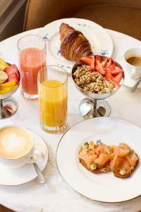 a table topped with plates of food and drinks at Hôtel Noucha in Paris