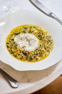 a white plate with a bowl of food on a table at Hôtel Noucha in Paris