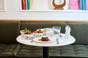 a table with a plate of food and glasses of water at Hôtel Noucha in Paris